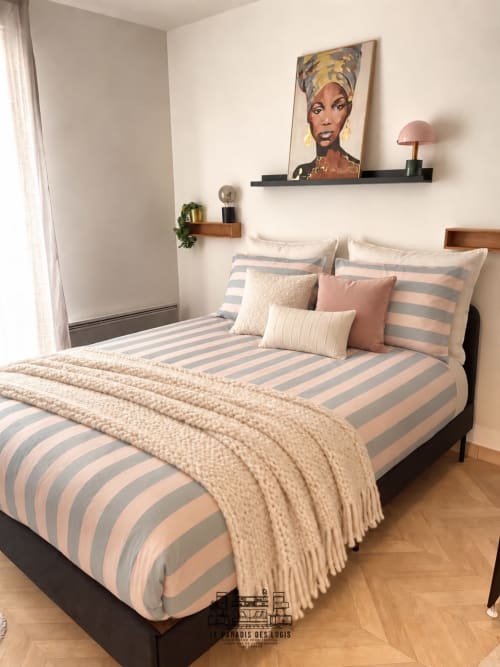 Chambre Cosy Luxe au Paradis Des Logis à Saint-Leu-la-Forêt avec literie rayée, coussins décorés et art mural moderne