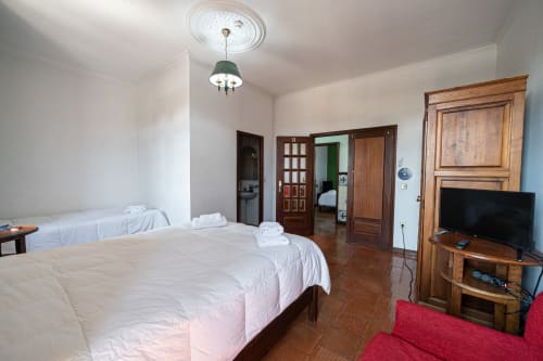 Suíte familiar espaçosa na Casa Augusta em Penafiel com camas de casal, TV, móveis em madeira e vista para a cidade