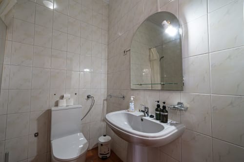 Casa Augusta, Suite 11 em Penafiel: banheiro moderno com azulejos, pia branca, espelho, sanitário e amenidades