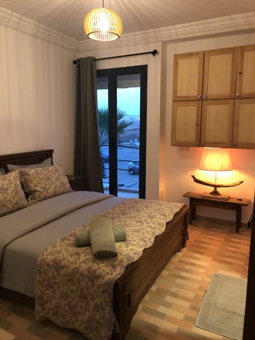 Coastal bedroom at Imsouane Surf Paradise with sea view, wooden bed, modern lighting, and ocean-facing balcony in Agadir,