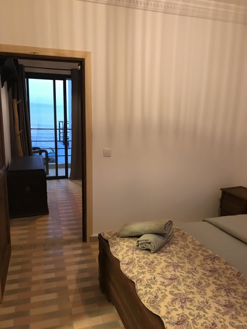 Bedroom with sea view at Imsouane Surf Paradise hotel, featuring bed with towels and open balcony overlooking ocean