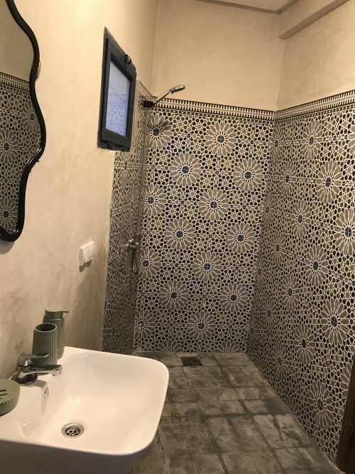Modern bathroom in Tiguemi room at Imsouane Surf Paradise with geometric tile walls, white sink, and shower area