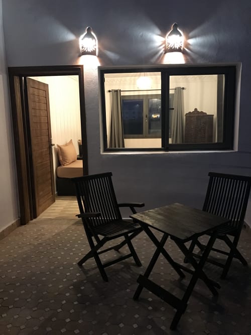 Balcony seating area at Imsouane Surf Paradise hotel with two black chairs overlooking sea view terrace
