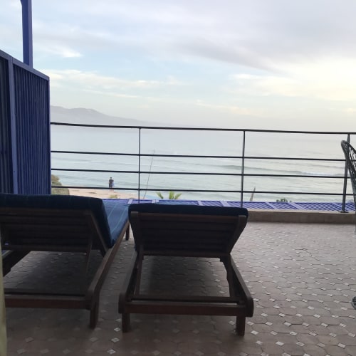 Oceanfront terrace at Imsouane Surf Paradise with lounge chairs overlooking the beach and sea view in Morocco