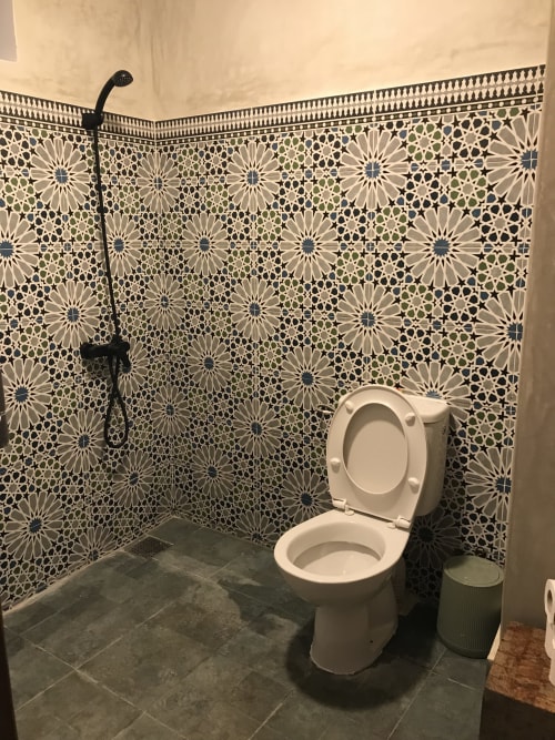 Modern bathroom in TILILT apartment at Imsouane Surf Paradise with geometric tile walls and shower fixtures