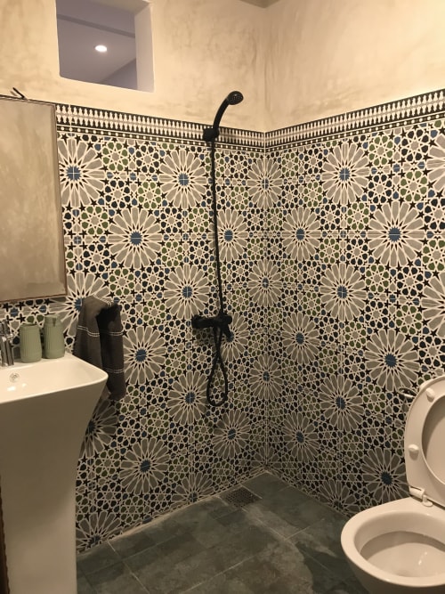 Modern bathroom with geometric patterned tiles, walk-in shower, and white fixtures at Imsouane Surf Paradise hotel in Morocco