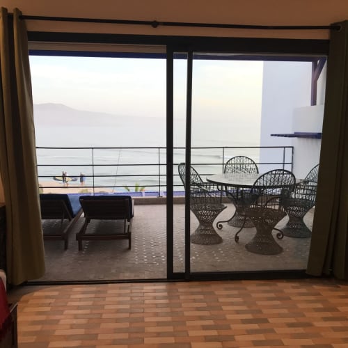 Sea view terrace at Imsouane Surf Paradise hotel with wicker chairs, dining table, and ocean vista in Imsouane, Morocco