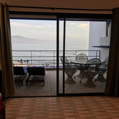 Oceanfront terrace at Imsouane Surf Paradise with wicker chairs, sea view, and beach access in Morocco