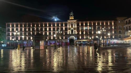 Noche lluviosa en la plaza del hotel Príncipe David en Toledo, España con la arquitectura histórica iluminada