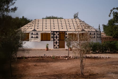 Riad marocain traditionnel au Domaine Belhazar, Essaouira, aux murs blancs et motifs géométriques sur le toit, entouré du désert