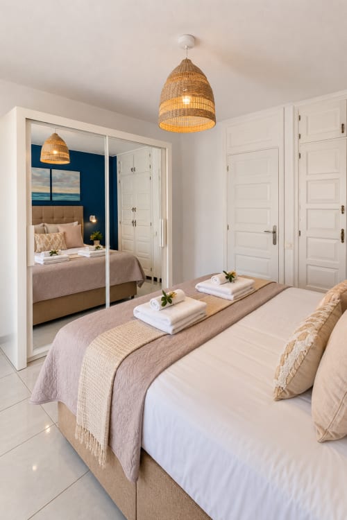 Elegance Duplex bedroom with woven pendant light, mirrored wardrobe, and neutral bedding at Manage Home Tenerife