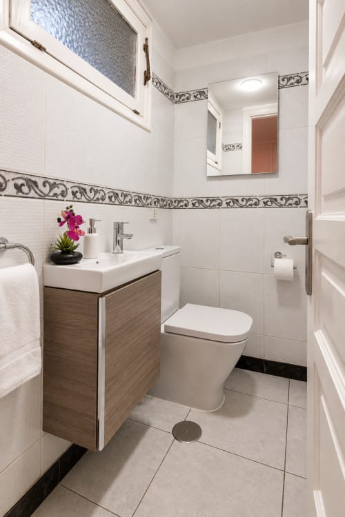 Modern bathroom in Elegance Duplex apartment at Manage Home Tenerife, Playa de las Américas with white tiles, wood vanity,