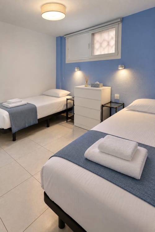 Modern bedroom at Manage Home Tenerife with twin beds, blue accents, and city views in Playa de las Américas