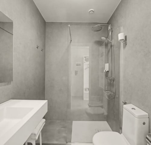 Bagno moderno all'Hotel Ca'Tron con doccia walk-in, lavabo bianco, toilette e piastrelle grigie