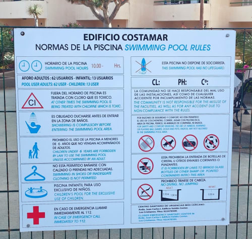 Swimming pool rules sign at Costamar building, Los Cristianos Tenerife with bilingual Spanish-English safety regulations and
