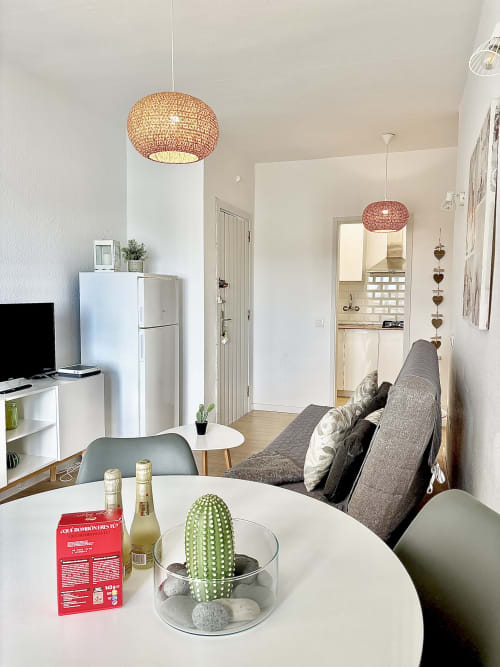 Modern studio apartment in Los Cristianos with open-plan living, kitchenette, dining table, sofa, woven pendant lights and