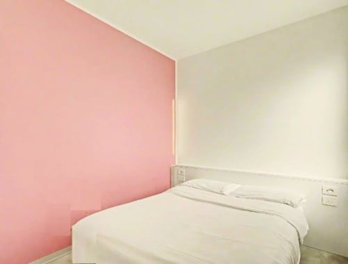 Habitación moderna en Hotel Ca'Tron en Dolo con pared de acento rosa y ropa de cama blanca