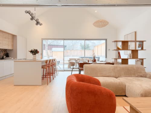 Modernes offenes Wohnzimmer im Vindihouses BnB in Epinac mit Terrakotta-Sessel, beigem Sofa und Küchenbereich