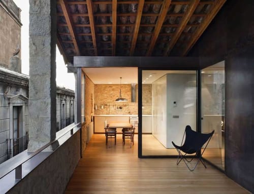 Modern terrace at Alemanys 5 cottage in Girona with wooden deck, contemporary seating, and glass doors opening to dining area