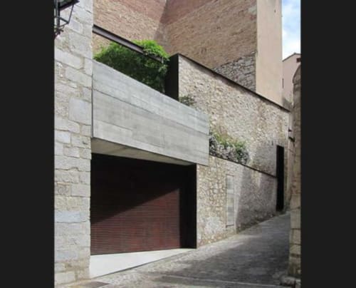 Modern cottage entrance at Alemanys 5 B&B in Girona with stone architecture and contemporary garage door