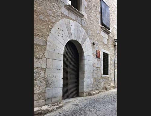 Medieval stone archway entrance with dark wooden door at Alemanys 5 cottage in Girona