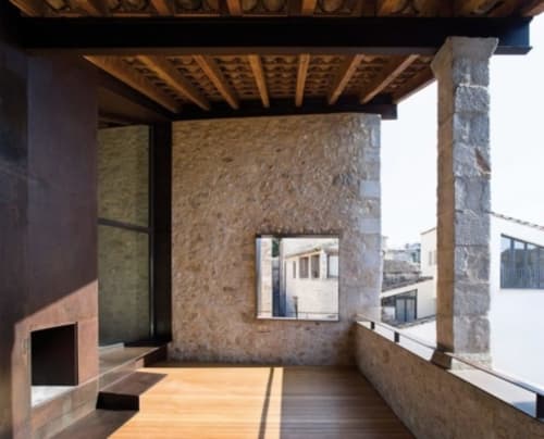 Modern terrace at Alemanys 5 apartment in Girona with wooden flooring, stone walls, and city views