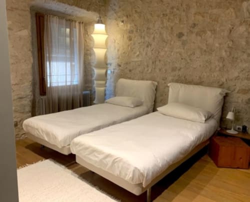 Twin bedroom at Alemanys 5 BnB in Girona with white bedding, stone walls, and pendant lighting