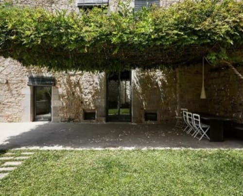 Contemporary patio at Alemanys 5 BnB Girona with stone walls, hedging, seating area