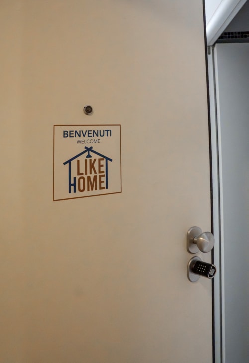 Porta beige con cartello 'Benvenuti Welcome Like Home' e serratura digitale presso l'appartamento LikeHome Ferrara