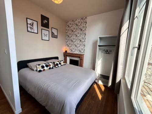 Gemütliches Schlafzimmer in Vindihouses Epinac mit Queensize-Bett, Kamin, Mustertapete und Tageslicht