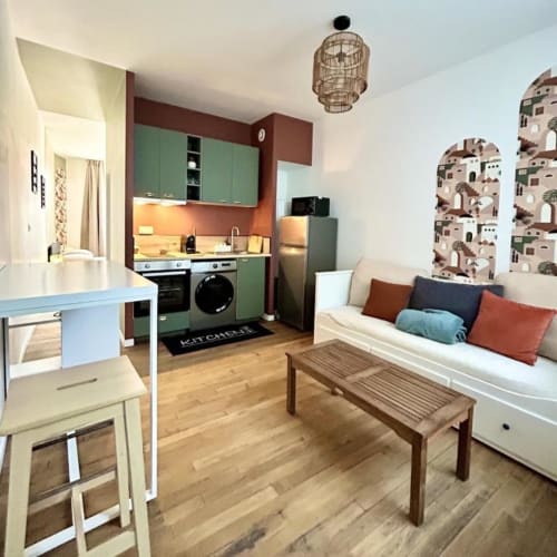 Modernes Studio-Apartment in Vindihouses Epinac mit grüner Küche, cremefarbenem Sofa, Holzböden und marokkanischer Dekoration