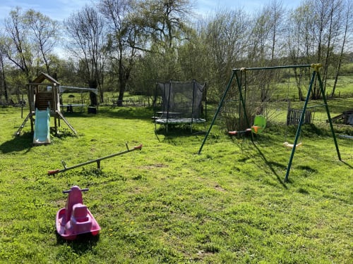 Aire de jeux extérieure avec balançoires, toboggan et trampoline à la maison d'hôtes Le Petit Moulin à Pouzauges