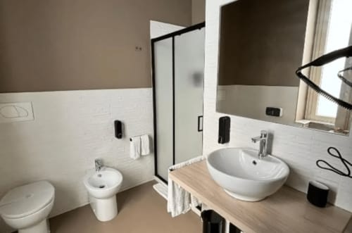 Modern bathroom at Moon Rooms By Celeste in Catania with dual sinks, toilet, and shower enclosure