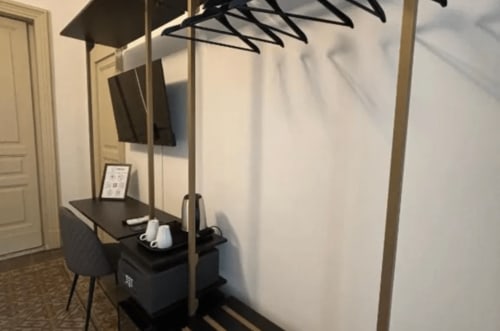 Modern workspace at Moon Rooms By Celeste in Catania with desk, chair, and artistic black sculptural lighting