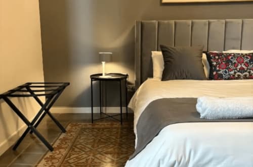 Modern bedroom at Moon Rooms By Celeste in Catania with neutral bedding, gray headboard, and contemporary furnishings