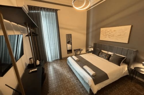 Modern bedroom at Moon Rooms By Celeste Rooms in Catania with queen bed, black headboard, and contemporary décor