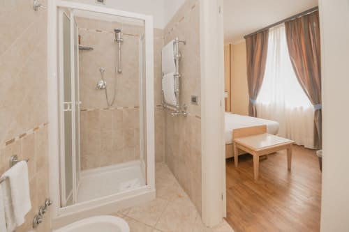 Bagno moderno con doccia e camera da letto al Green Hotel Poggio Regillo di Frascati