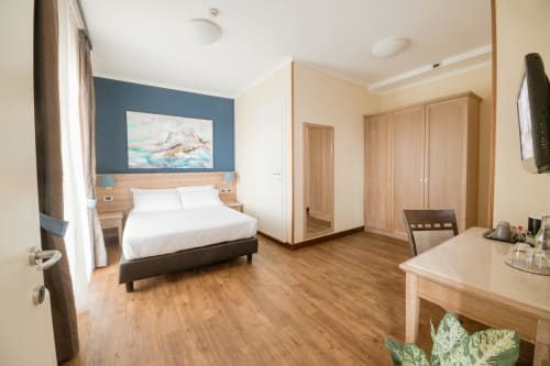 Junior Suite moderna al Green Hotel Poggio Regillo di Frascati con arredamento in legno, opere d'arte con vista sul giardino e confortevole