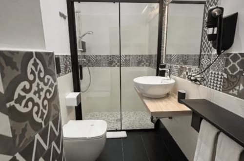 Bagno moderno presso Moon Rooms By Celeste a Catania con piastrelle decorate, doccia walk-in e lavabo rotondo