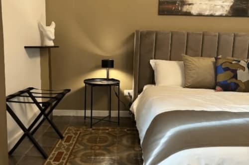 Camera moderna di Moon Rooms By Celeste a Catania con letto, poltrona e tavolino