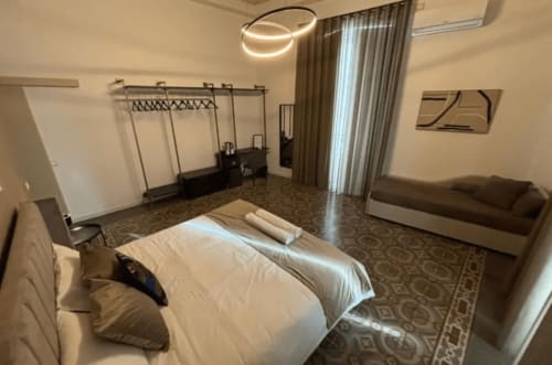 Camera moderna presso Moon Rooms By Celeste a Catania con letto, zona living e illuminazione contemporanea