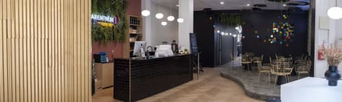 Modern hotel lobby at Résidence Aurmat in Boulogne with black reception desk, wooden wall, and seating area