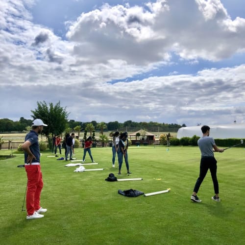 Golf lesson on green lawn at Résidence Aurmat hotel in Boulogne-Billancourt with participants and instructor