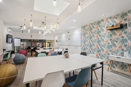 Modern coworking space at Résidence Aurmat boutique hotel in Boulogne-Billancourt with collaborative tables and vibrant