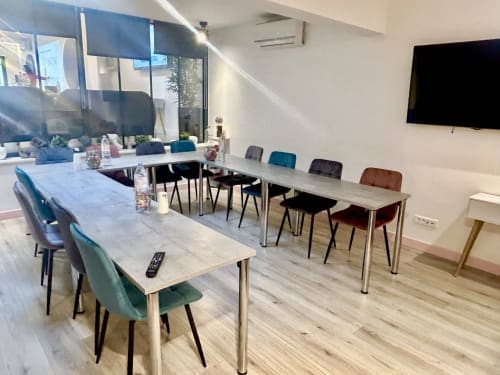 Modern meeting room at Résidence Aurmat boutique hotel in Boulogne-Billancourt with multiple tables, colorful chairs, and