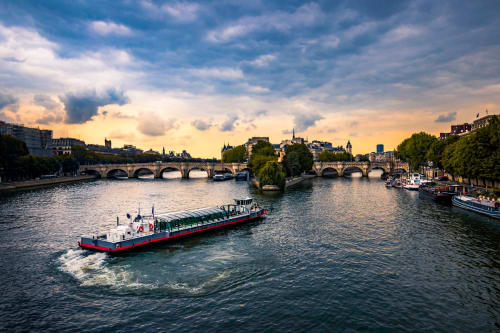 Péniche sur la Seine près de Boulogne-Billancourt avec les ponts parisiens et le paysage urbain au coucher de soleil