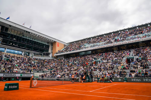 Roland Garros clay tennis court with packed stadium seating in Boulogne-Billancourt, Paris