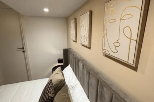 Minimalist bedroom at Moon Rooms By Celeste in Catania with bed, radiator, and abstract line art wall decor