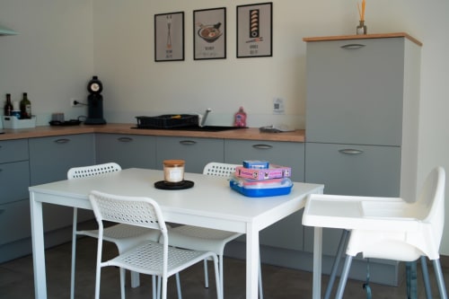 Modern kitchen and dining area in Tokyo apartment at Résidence des Sables, Mably with white table and chairs
