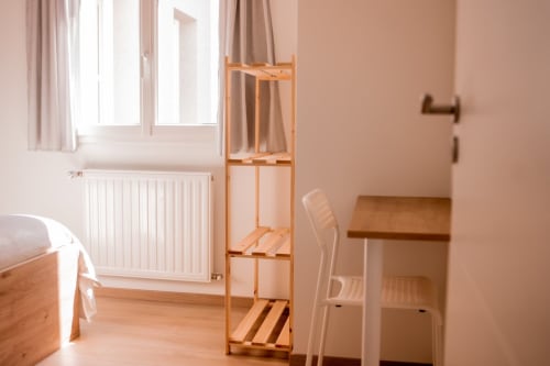 Bright apartment bedroom at Résidence des Sables with wooden bunk bed, radiator, and large windows in Mably, France